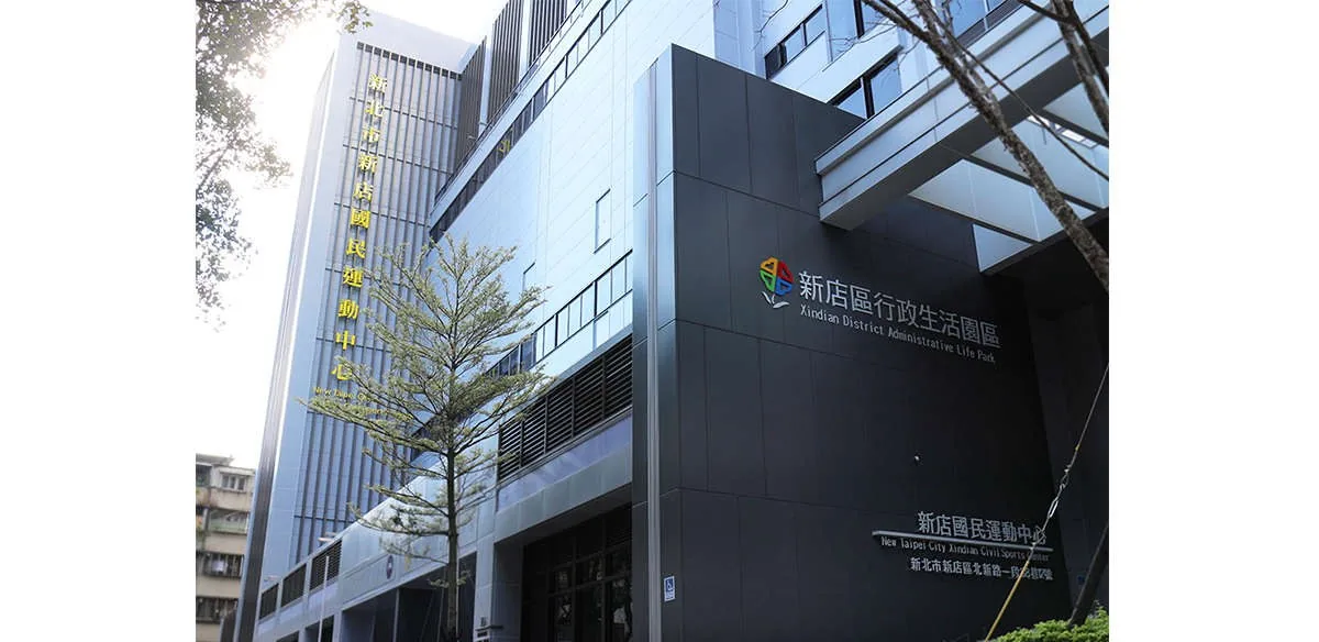 運動中心外觀,深色帷幕大樓與行政生活園區招牌
