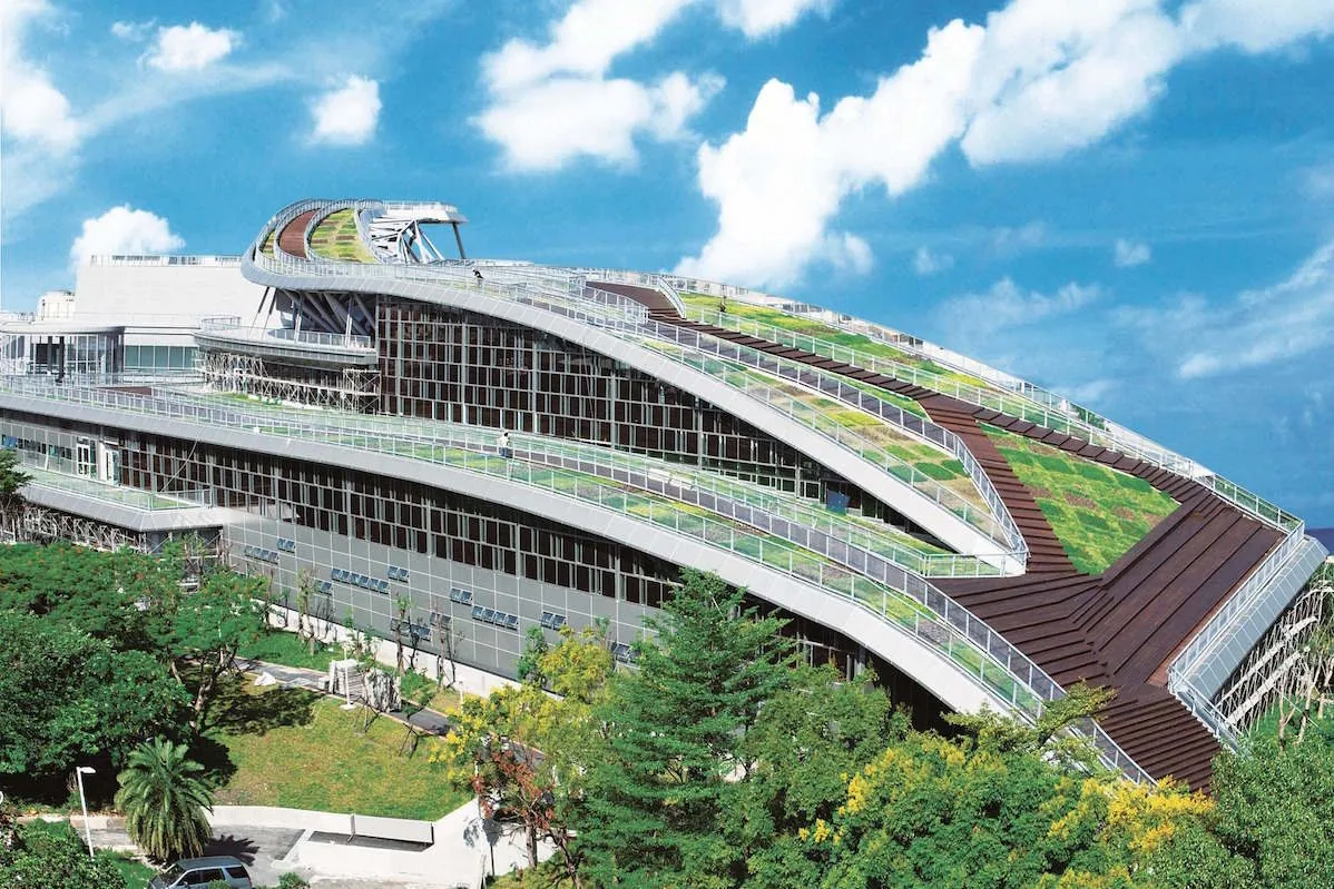 運動中心外觀，弧形量體上方為大面積綠屋頂植栽